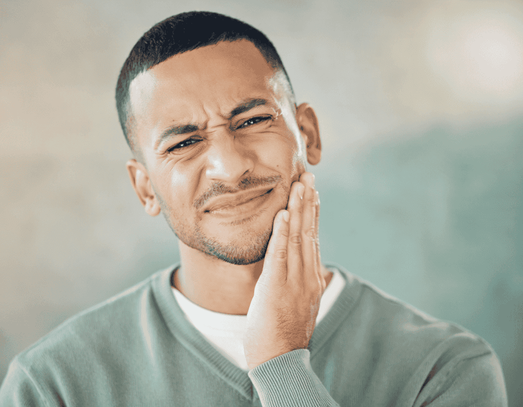 Man holds a painful side of his jaw – unilateral jaw pain at the temporomandibular joint, JUST KFO Cologne